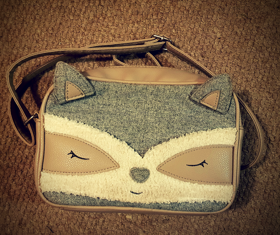 Grey and Beige over the shoulder hand bag designed to look like a raccoon face.