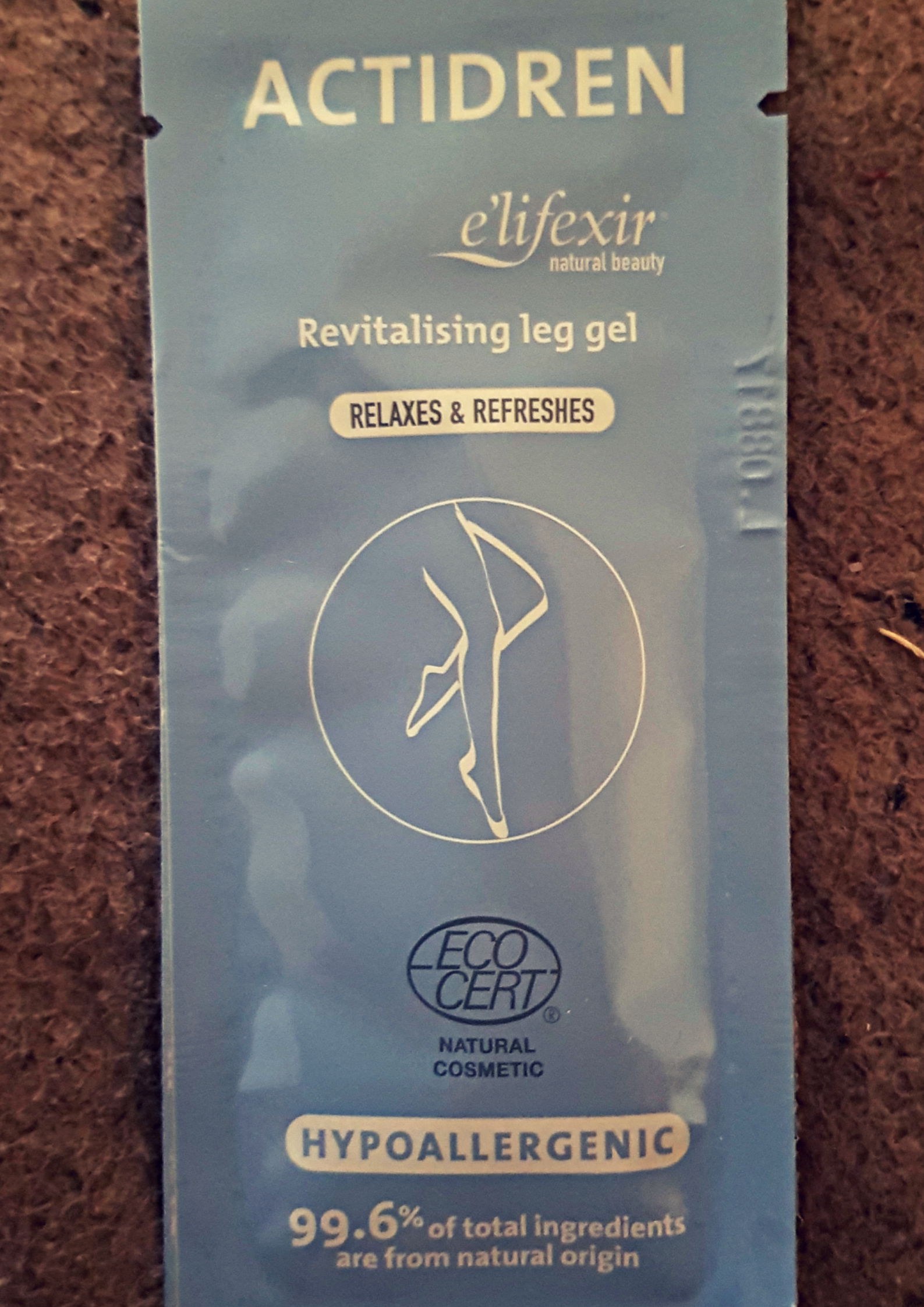 Purple sachet with elifxir actidren revitalising leg gel and a diagram of a pair of legs