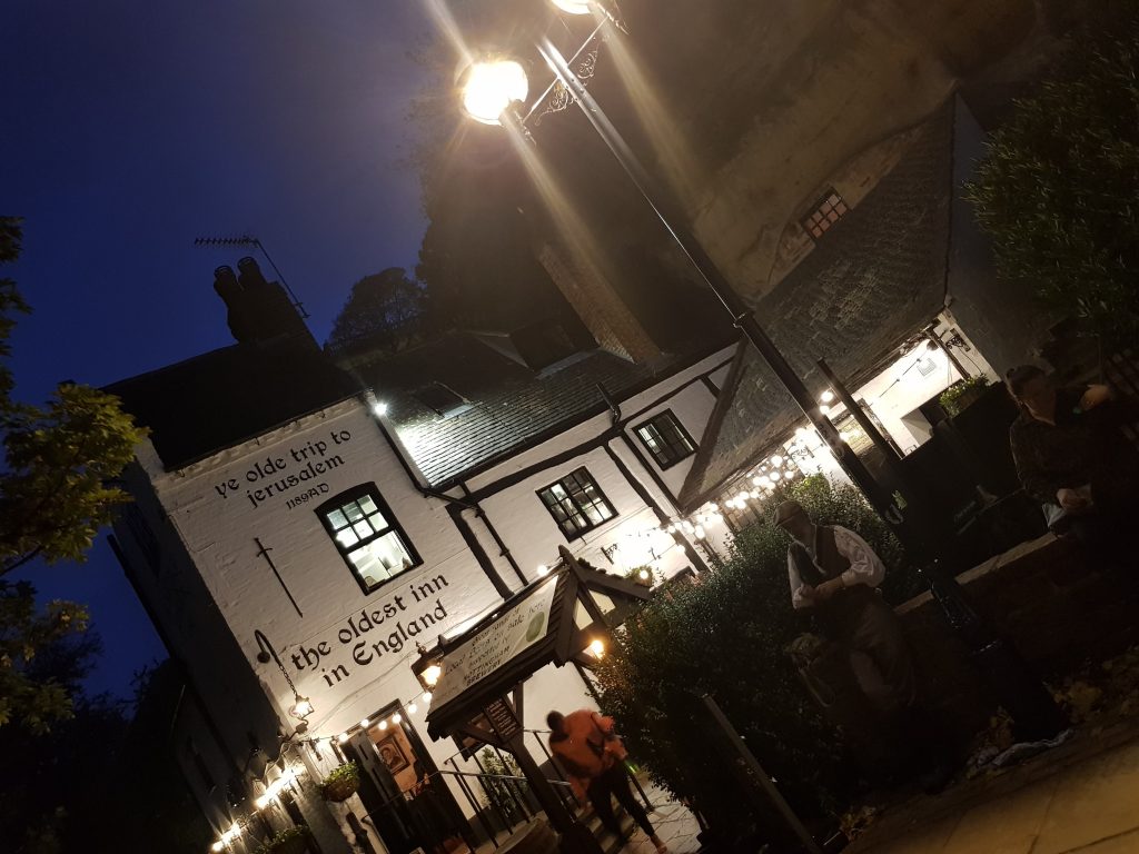 Outside of Ye Olde Trip to Jerusalem. A White pub with black roof. Outside sits Gary the Co-owner of the Original Nottingham Ghost Walk