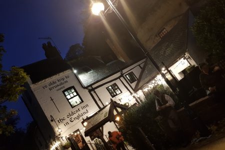 Outside of Ye Olde Trip to Jerusalem. A White pub with black roof. Outside sits Gary the Co-owner of the Original Nottingham Ghost Walk