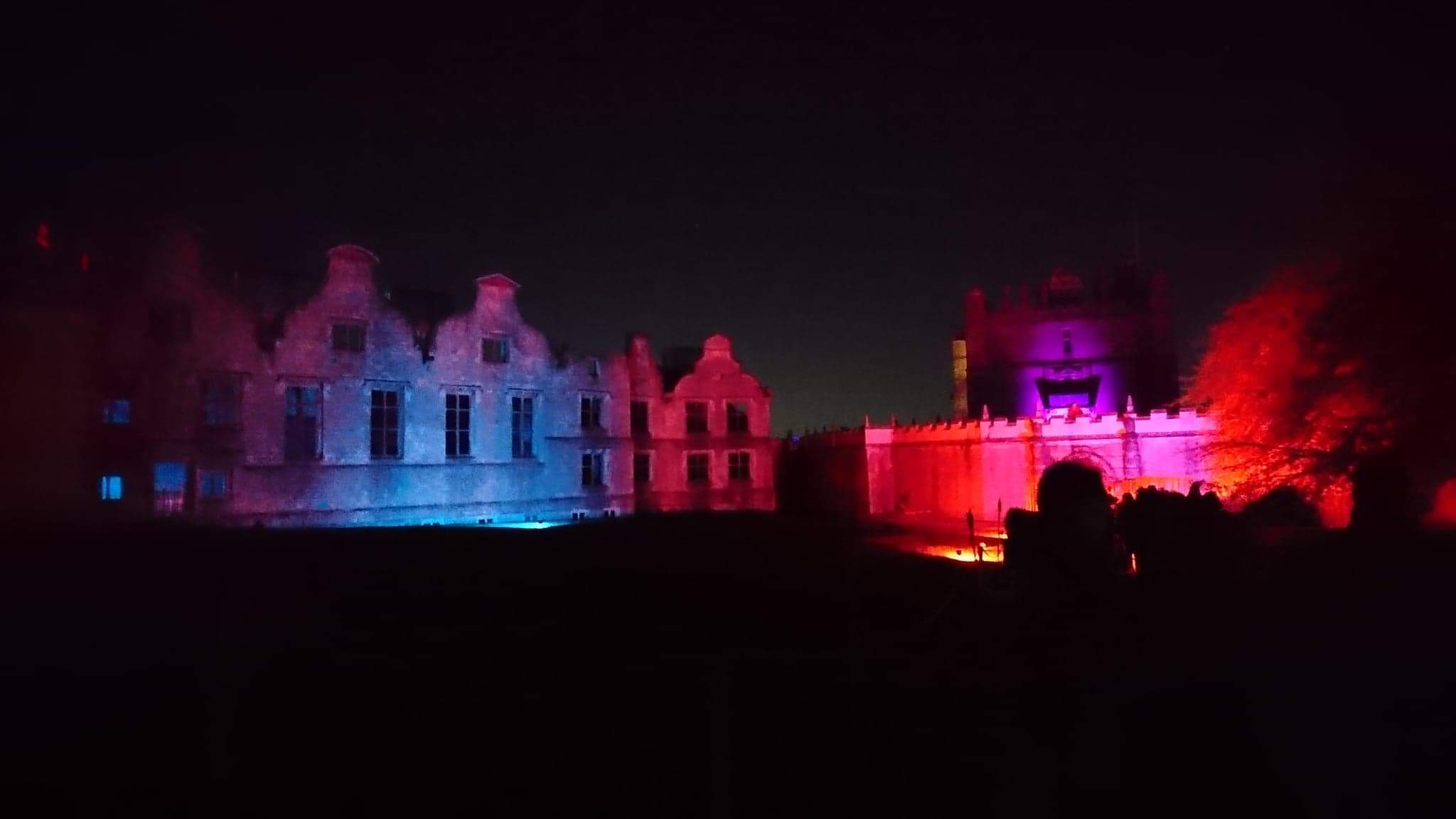 A night time shot of the ruins of Bolsover Castle and the little castle lit up with eerie purple lighting on Halloween Night