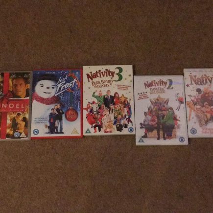 DVD boxes of Christmas films layed out. The films are The Holiday, Noel, Jack Frost, Nativity! Nativity 2, Nativity 3 and Phineas and Ferb the movie.