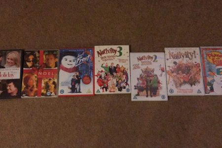 DVD boxes of Christmas films layed out. The films are The Holiday, Noel, Jack Frost, Nativity! Nativity 2, Nativity 3 and Phineas and Ferb the movie.