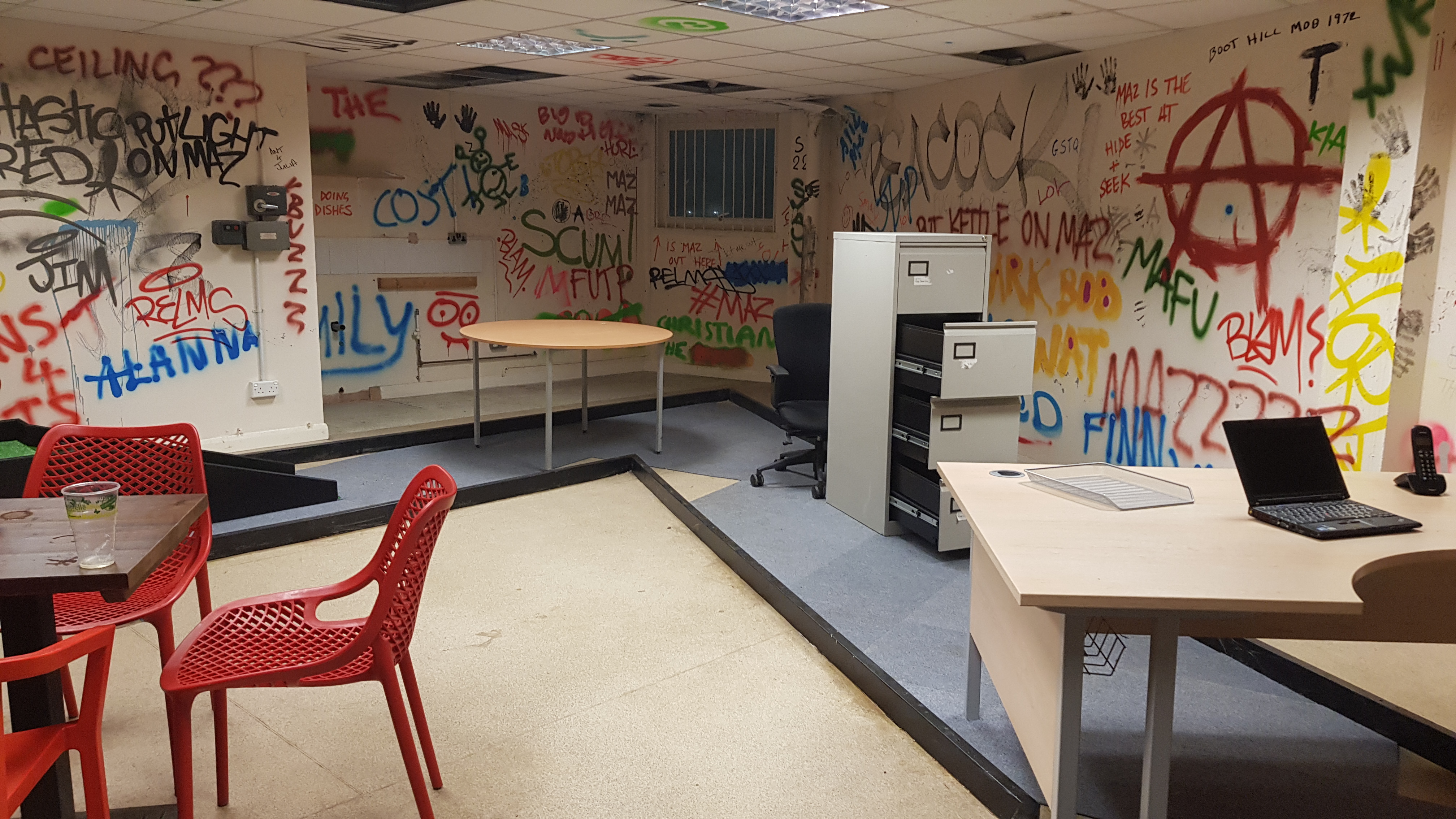 One of the holes at Caddyshackers mini golf based on an office room. The ball goes under a computer desk, around a filing cabinet and under a meeting table. The walls of the room are white and absolutely covered in multi-coloured graffiti