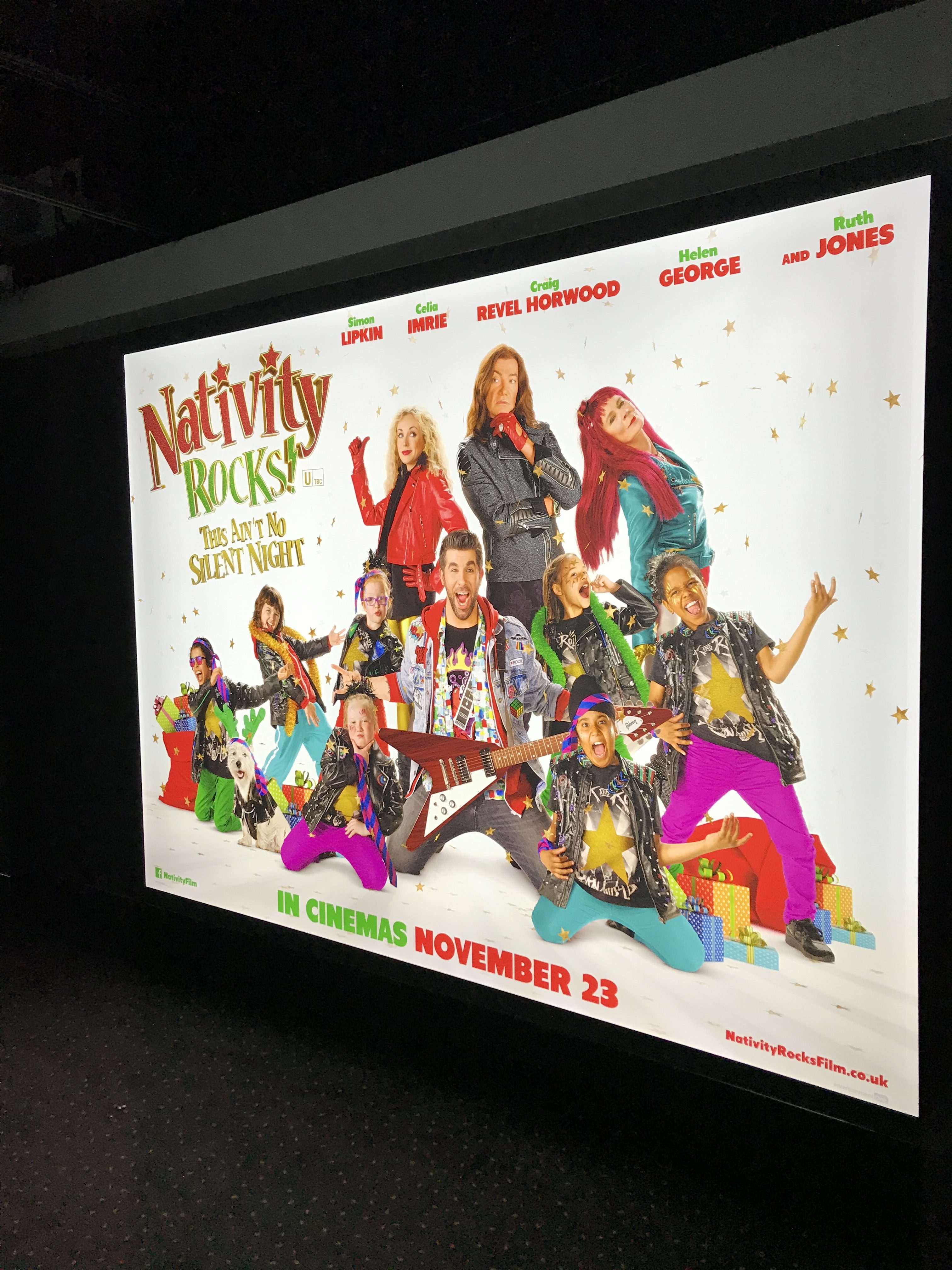 A poster for Nativity rocks! Christmas film. The main character is in the middle of the screen on his knees with an electric guitar while kids stand all around him. In the corner it says Nativity Rocks! This ain't no silent night. 