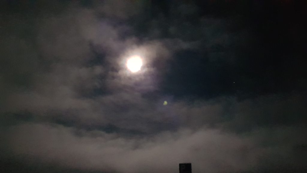 A full moon in the night sky over Reykjavik