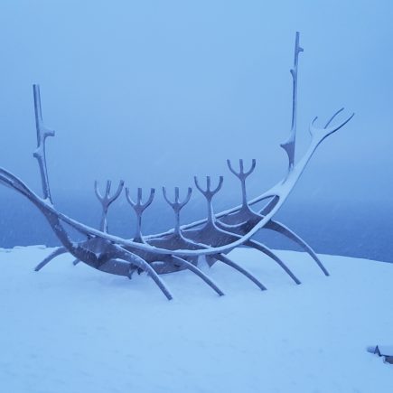 The Sun Voyager statue in Reykjavik, Iceland. A statue made of metal to look like a viking ship with snow all around