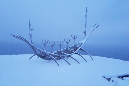 The Sun Voyager statue in Reykjavik, Iceland. A statue made of metal to look like a viking ship with snow all around