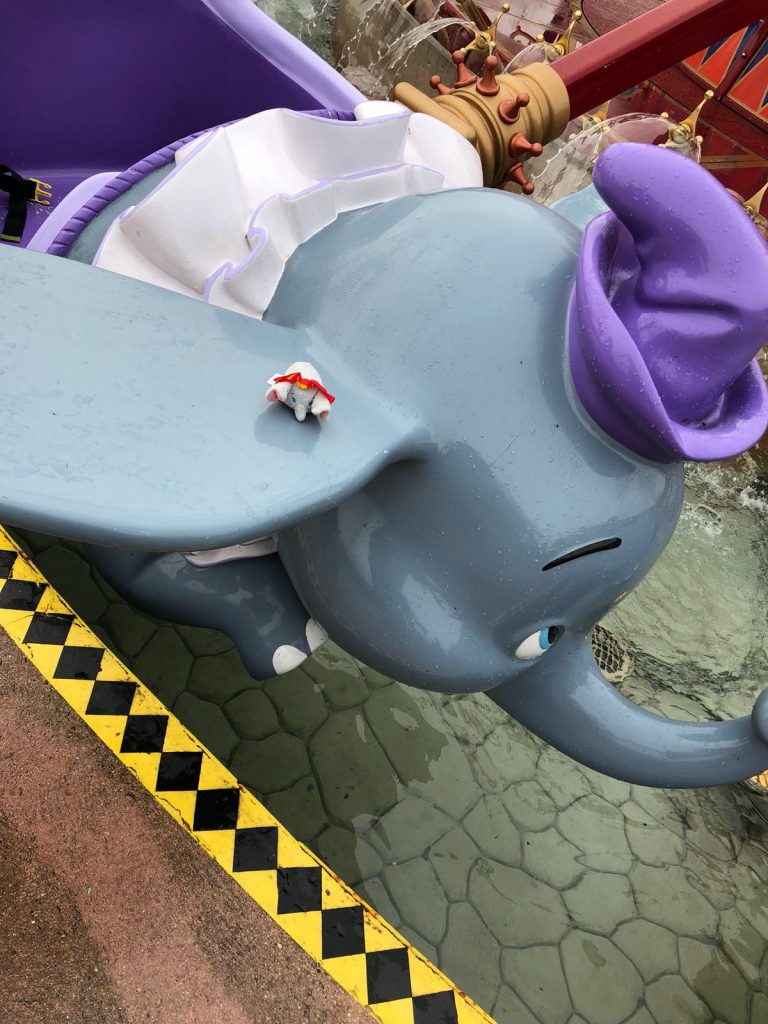 Dumbo tsum tsum on the Dumbo the flying elephant ride at Disneyland Paris. A grey plastic elephant wearing a purple hat and outfit