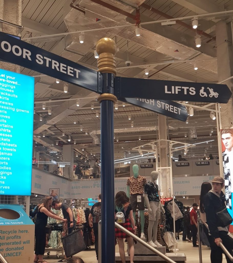 A street sign found in Primark pointing to Moor Street, High Street and the lifts upstairs