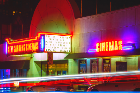 Old fashioned style cinema with retro neon signs showing wanderlust movies