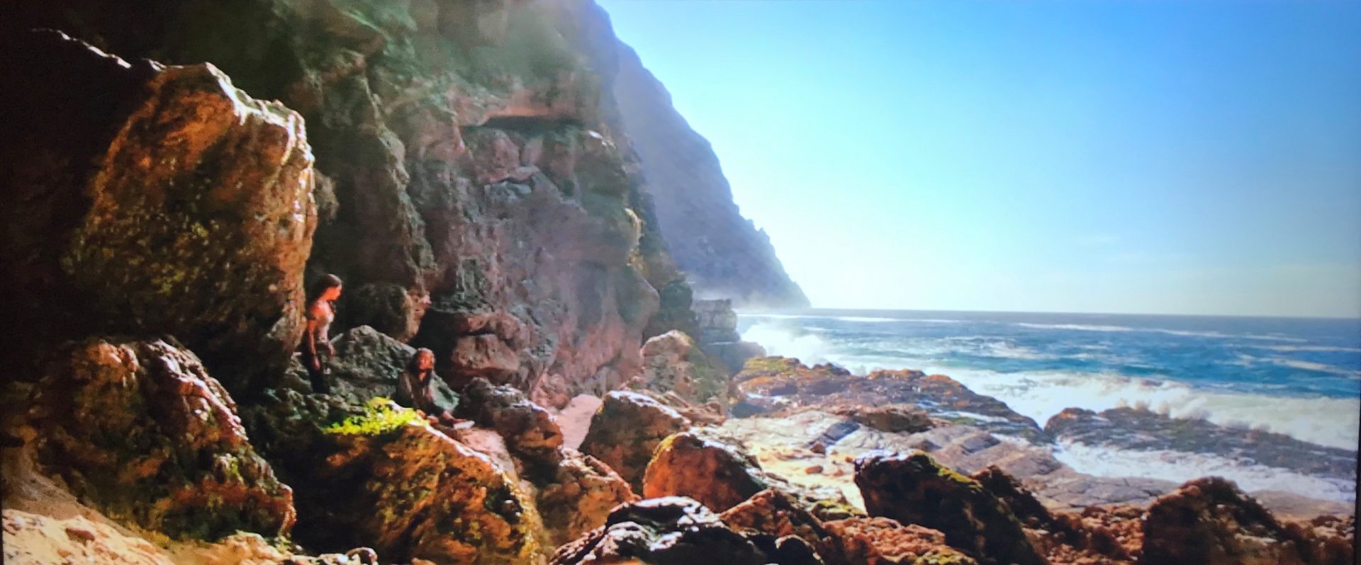 A scene from the Tomb Raider movie where Lara Croft is on a beach looking out over the sea