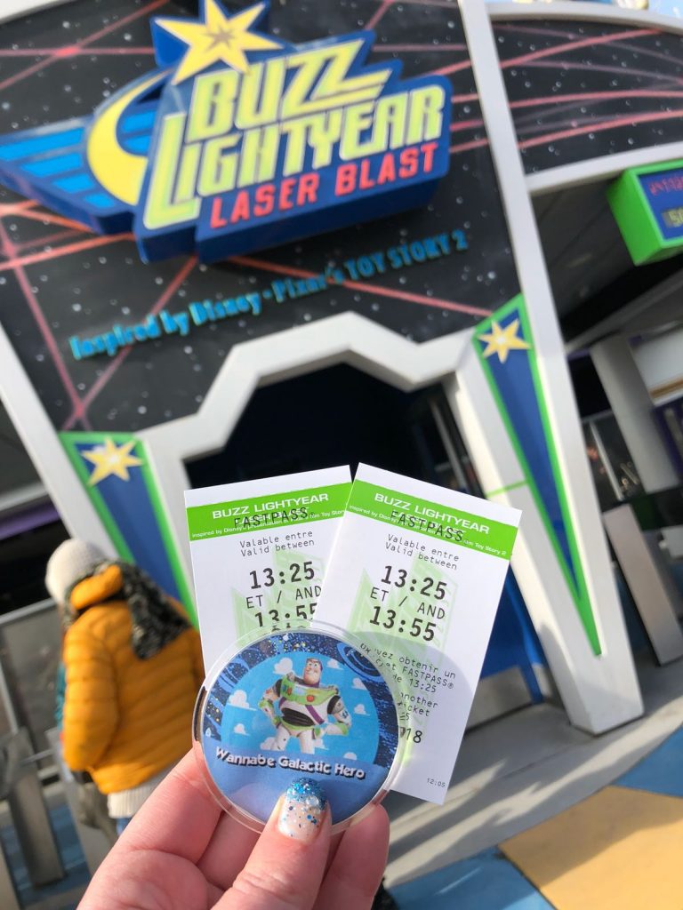 Two Disneyland Paris fastpass tickets for Buzz Lightyear Laser Blast in front ot the door to the ride with its title above.
