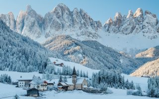 The small village Val di Funes covered in snow, with Dolomites mountains, South Tyrol, Italy.
