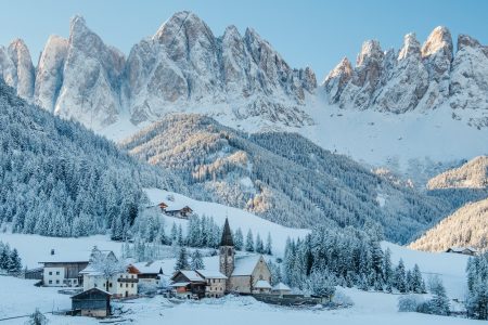 The small village Val di Funes covered in snow, with Dolomites mountains, South Tyrol, Italy.